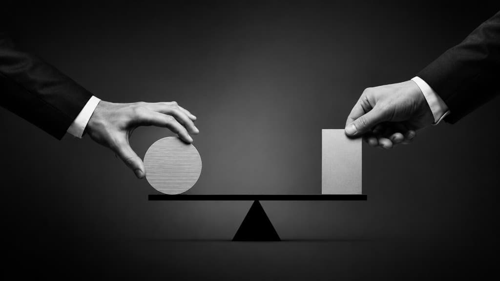Balance scale held by hands, illustrating the value versus growth investing metaphor.